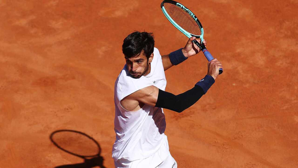 Lorenzo Musetti ejecutando un revés a una mano en tierra batida