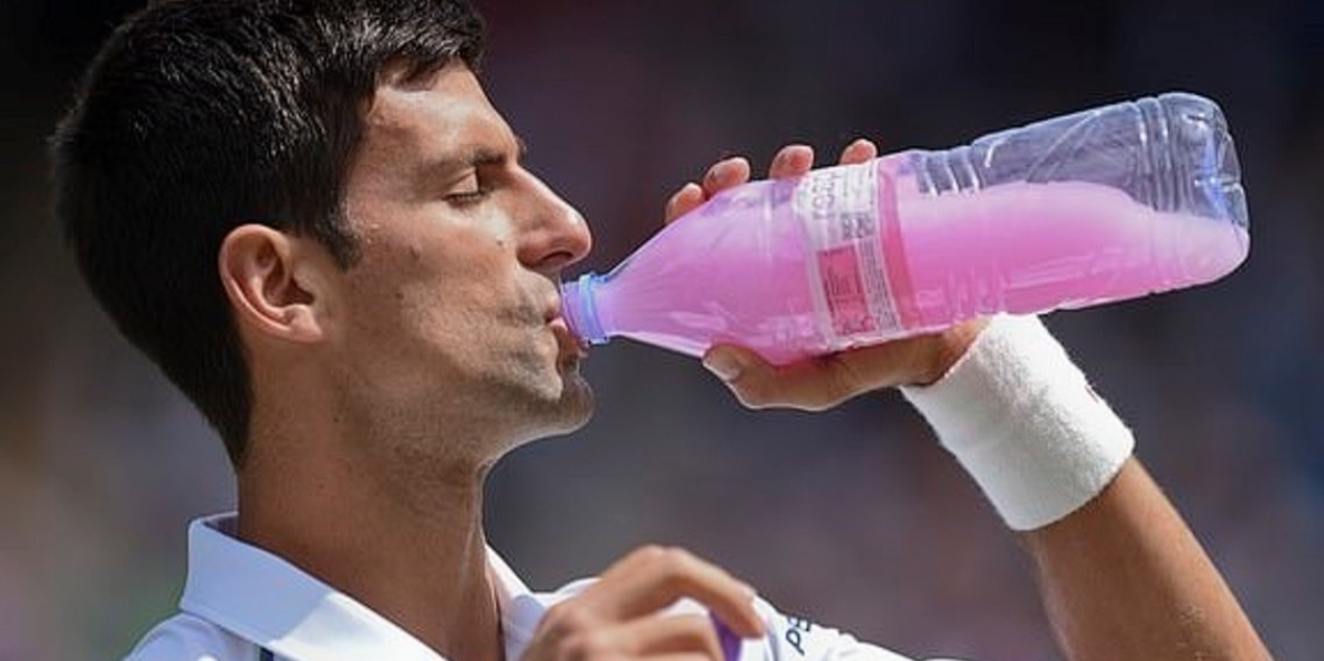 El tenista Novak Djokovic se hidrata durante un partido con una bebida rosa